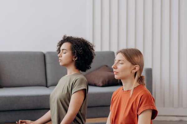 Person in a focused yoga pose in a minimalist room.